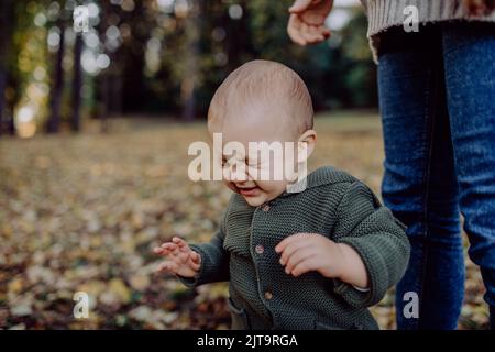 Mère avec son petit fils portant un pull tricoté pendant la marche dans la nature, gros plan Banque D'Images