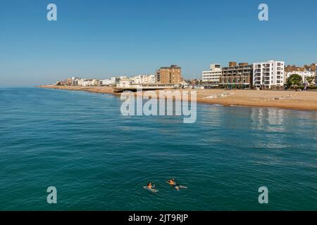 Angleterre, West Sussex, Worthing, Two Women Swimming in the Sea et Beach Skyline Banque D'Images