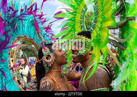 Notting Hill, Londres, Royaume-Uni. 29th août 2022. Le plus grand festival de rue d'Europe est revenu dans les rues de Notting Hill après les années annulées en raison de la pandémie de Covid. Des danseurs exotiques et des groupes musicaux sur le thème jamaïcain défileront dans les rues, avec de la nourriture et des divertissements dans la rue autour de la région, ajoutant à l'événement. Le Grand Parade a lieu le lundi des fêtes de la Banque comme point culminant du festival de trois jours qui a commencé en 1966. Les participants se rassemblent à proximité dans leurs costumes colorés. Des amis masculins et féminins dans des coiffes aux couleurs vives Banque D'Images