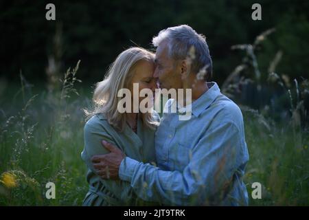 Portrait d'un couple aîné affectueux qui s'embrasse dans la nature. Banque D'Images