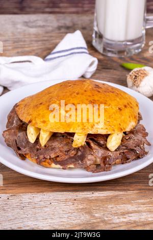 Viande entre les petits pains. Beignet de viande dans du pain gras sur fond de bois. Cuisine turque traditionnelle. Gros plan. Nom local tombik et doner Banque D'Images