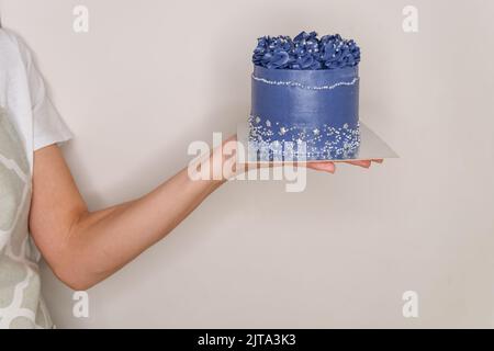 Belle jeune femme souriante avec un gâteau au chocolat. Banque D'Images