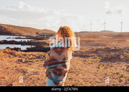 Une femme se tenant et s'embrassant en profitant d'un beau paysage avec des éoliennes en arrière-plan et sur la côte océanique. Concept de gens aiment tr Banque D'Images