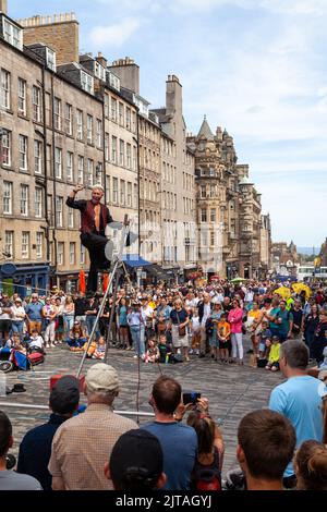 Un bus du Festival d'Édimbourg sur le Royal Mile effectuant des randonnées en corde raide Banque D'Images