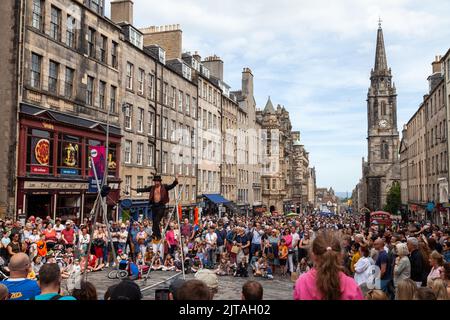 Un bus du Festival d'Édimbourg sur le Royal Mile effectuant des randonnées en corde raide Banque D'Images