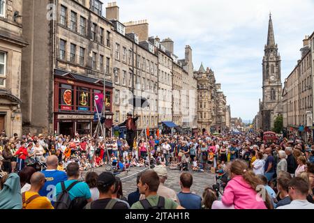 Un bus du Festival d'Édimbourg sur le Royal Mile effectuant des randonnées en corde raide Banque D'Images