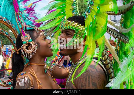 Notting Hill, Londres, Royaume-Uni. 29th août 2022. Le plus grand festival de rue d'Europe est revenu dans les rues de Notting Hill après les années annulées en raison de la pandémie de Covid. Des danseurs exotiques et des groupes musicaux sur le thème jamaïcain ont défilé dans les rues, avec des repas et des divertissements dans la rue dans la région, ajoutant à l'événement. Le Grand Parade a lieu le lundi des fêtes de la Banque comme point culminant du festival de trois jours, qui a commencé en 1966. Les participants noirs, hommes et femmes, en costumes exotiques, se saluent mutuellement Banque D'Images