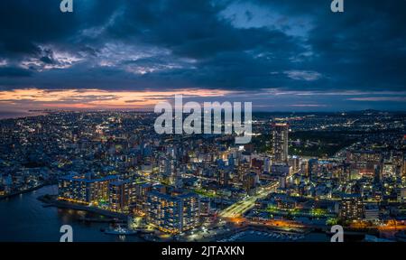 Un coucher de soleil spectaculaire s'attarde dans le ciel au-dessus du centre-ville d'Akashi City au crépuscule Banque D'Images