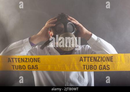 Un ingénieur médical portant un masque antigaz expérimenté dans la crise des fuites de gaz dirigeant l'urgence pendant le chaos.Sur la bande jaune, le n Banque D'Images