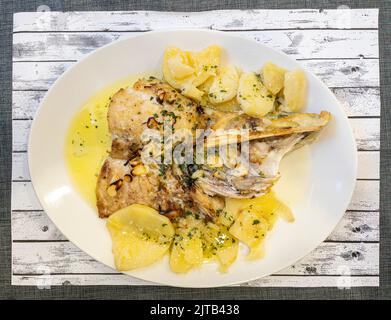 Hake la nuque coupée sur le gril, assaisonnée avec de l'huile de persil et de l'ail. Cuisine basque. Banque D'Images