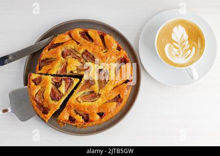 Gros plan sur une table en bois blanc avec une tarte aux figues maison et une tasse de cappuccino au café. Vue de dessus. Banque D'Images