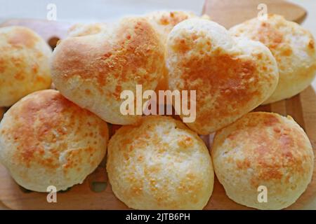 Pile de pain de Pao de Queijo ou de fromage brésilien maison fraîchement cuits avec une paire de coeur en forme de dessus Banque D'Images