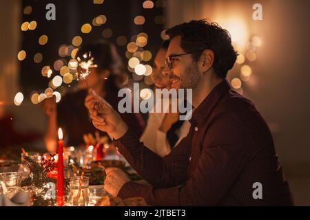 des amis heureux avec des spamisseurs au dîner de noël Banque D'Images