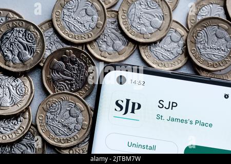 Application SJP vue sur l'écran du smartphone placée sur des pièces en livres sterling. St. James's place (SJP) est une société de conseil financier expert. Stafford, unité Banque D'Images