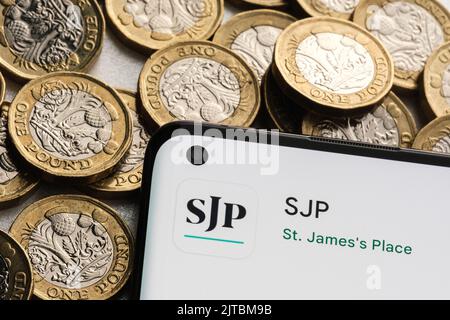 Application SJP vue sur l'écran du smartphone placée sur des pièces en livres sterling. St. James's place (SJP) est une société de conseil financier expert. Stafford, unité Banque D'Images