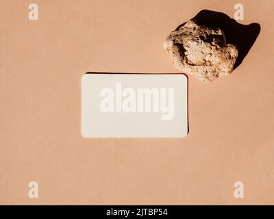 Maquette de carte de visite et pierre sur fond beige. Copier l'espace. Flat Lay modèle de marque commerciale minimal couleur neutre. Maquette de carte. Banque D'Images