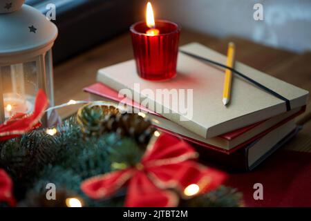 couronne de noël, livres, bougie, lanterne sur la fenêtre Banque D'Images