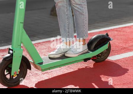 femme en scooter le long de la piste cyclable dans la ville Banque D'Images