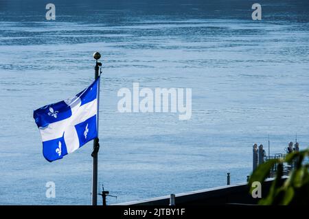 Drapeau de la province de Québec, avec son motif fleur de lis, survole le fleuve Saint-Laurent à Québec, Canada. Banque D'Images