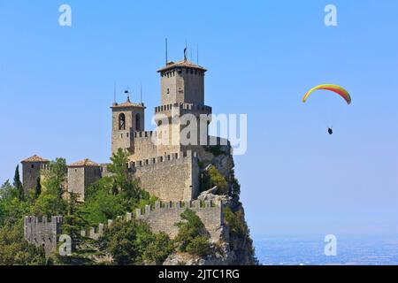 Un parapente avec une voile Geronimo 2 survolant la forteresse de Guaita datant de 11th ans sur le Monte Titano à Saint-Marin Banque D'Images