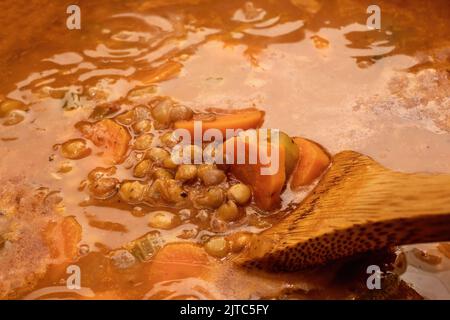 Soupe de lentilles avec carottes et oignons bouillant dans une casserole. Banque D'Images