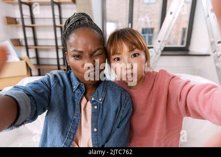 les femmes qui prennent le selfie et font des visages chez elles Banque D'Images