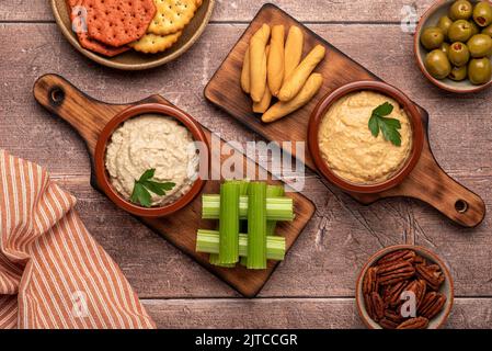 Photographie de nourriture de hors-d'œuvre, de houmous, de céleri, de craquelins, d'olives Banque D'Images