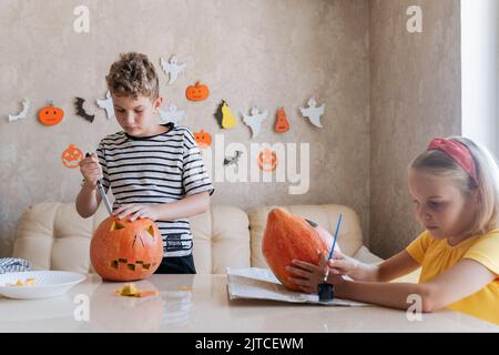 Les enfants se préparent à l'Halloween, à la coloration et à la coupe des citrouilles. Banque D'Images