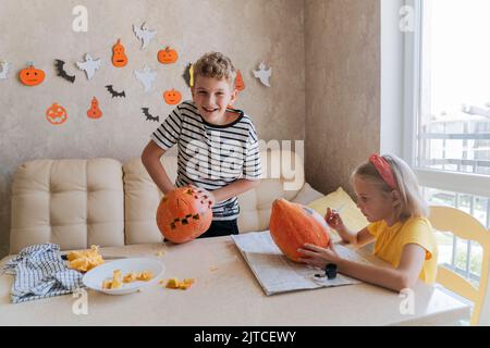 Les enfants se préparent à l'Halloween, à la coloration et à la sculpture des citrouilles. Banque D'Images