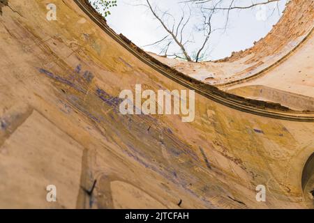 Mur de l'église endommagé avec des fresques défraîchi et une tour sans toit. Ciel et arbres. Ruines de l'église abandonnée à Lubycza Klolewska. Vue horizontale. Photo de haute qualité Banque D'Images