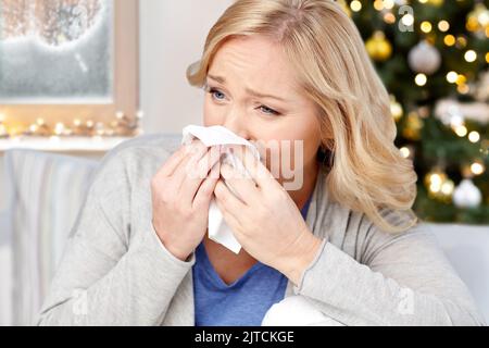 femme soufflant le nez à papier mouchoir à noël Banque D'Images