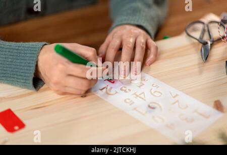 les mains avec le pochoir et le dessin de marqueur sur noël Banque D'Images