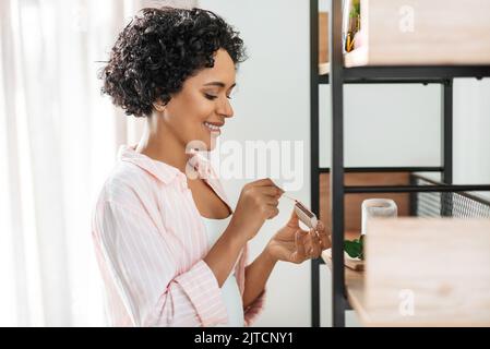 femme avec allumettes éclairant des bougies à la maison Banque D'Images