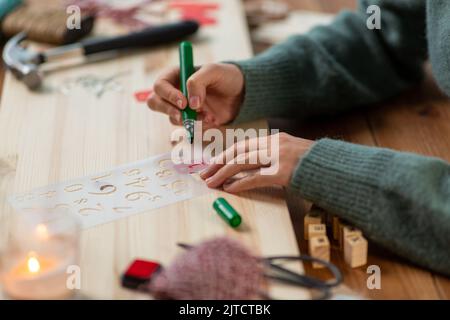 les mains avec le pochoir et le dessin de marqueur sur noël Banque D'Images