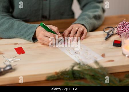 les mains avec le pochoir et le dessin de marqueur sur noël Banque D'Images