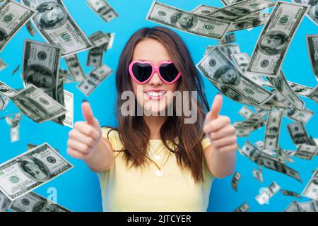 femme en lunettes de soleil montre les pouces vers le haut sur l'argent Banque D'Images