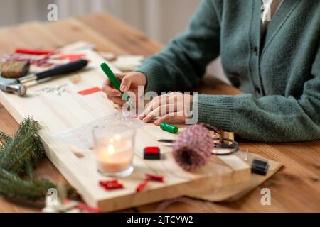 les mains avec le pochoir et le dessin de marqueur sur noël Banque D'Images