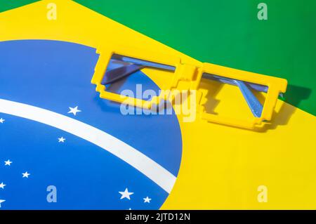 Lunettes aux couleurs du Brésil, jaune et bleu vert, concept de la coupe du monde avec fond jaune. Banque D'Images