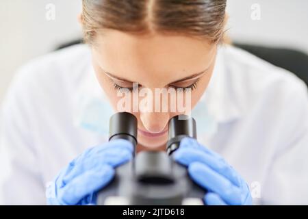 Observez attentivement pour aider à maintenir la précision. Une jeune scientifique femme travaillant dans un laboratoire. Banque D'Images