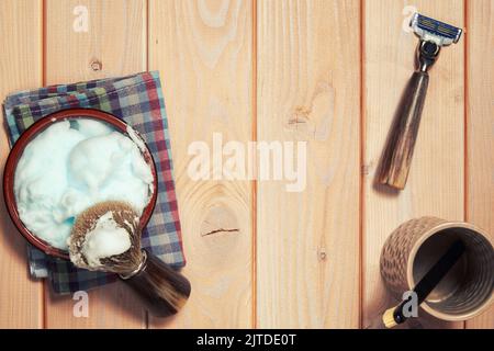 Crème à raser et brosse sur la table en bois du barbershop. Soins de la peau et rasage des fonds Banque D'Images