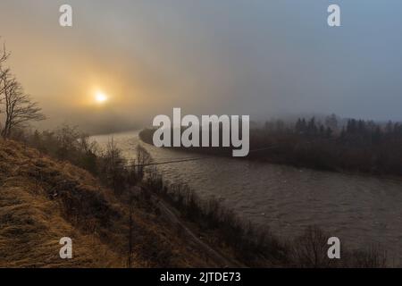 Rivière Stormy dans les montagnes avec un pont suspendu sur un matin mystique de brume. La rivière Styi dans les Carpates ukrainiens dans un m de brouillard mystique Banque D'Images