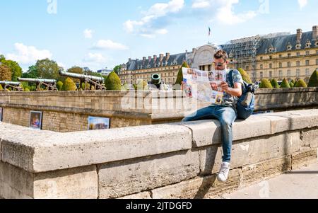 Jeunes hommes avec une carte touristique à portée de main dans la ville de Paris France. Homme touristique à Paris Banque D'Images