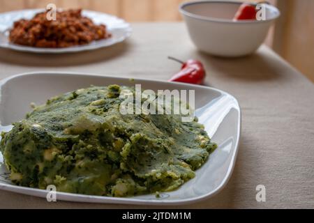 Une assiette de Mukimau — nourriture kenyane traditionnelle faite à l'aide de purée de pommes de terre.— prise du point de vue du dîner. Banque D'Images