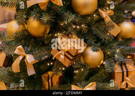 Arrière-plan des fêtes de Noël et du nouvel an. Sapin de Noël décoré de boules dorées et de boîtes-cadeaux. Concept de célébration Banque D'Images