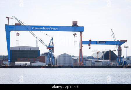 Kiel, Allemagne. 15th août 2022. Deux grues et plusieurs halls de chantier naval peuvent être vus sur le site du chantier naval ThyssenKrupp Marine Systems (TKMS) et des chantiers navals allemands Kiel GmbH dans le port de Kiel. Credit: Christian Charisius/dpa/Alay Live News Banque D'Images