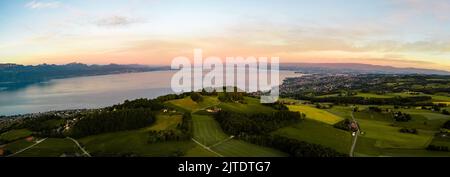 Vue panoramique aérienne sur un village verdoyant au bord du lac Léman en Suisse au coucher du soleil Banque D'Images