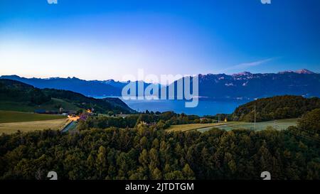 Une vue aérienne sur un village verdoyant au bord du lac Léman en Suisse au coucher du soleil Banque D'Images