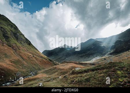 Tôt le matin sur une pente de montagne et les rayons du soleil passant vrai les nuages. Paysage de sommet de montagne. Paysage montagnard européen. Banque D'Images