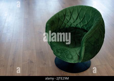 Élégant fauteuil rond en velours vert dans un intérieur moderne. Mise au point sélective douce. Banque D'Images