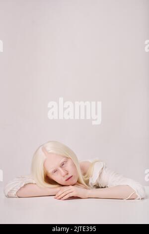 Portait de albino fille avec blanc cheveux longs regardant la caméra isolées sur fond blanc Banque D'Images